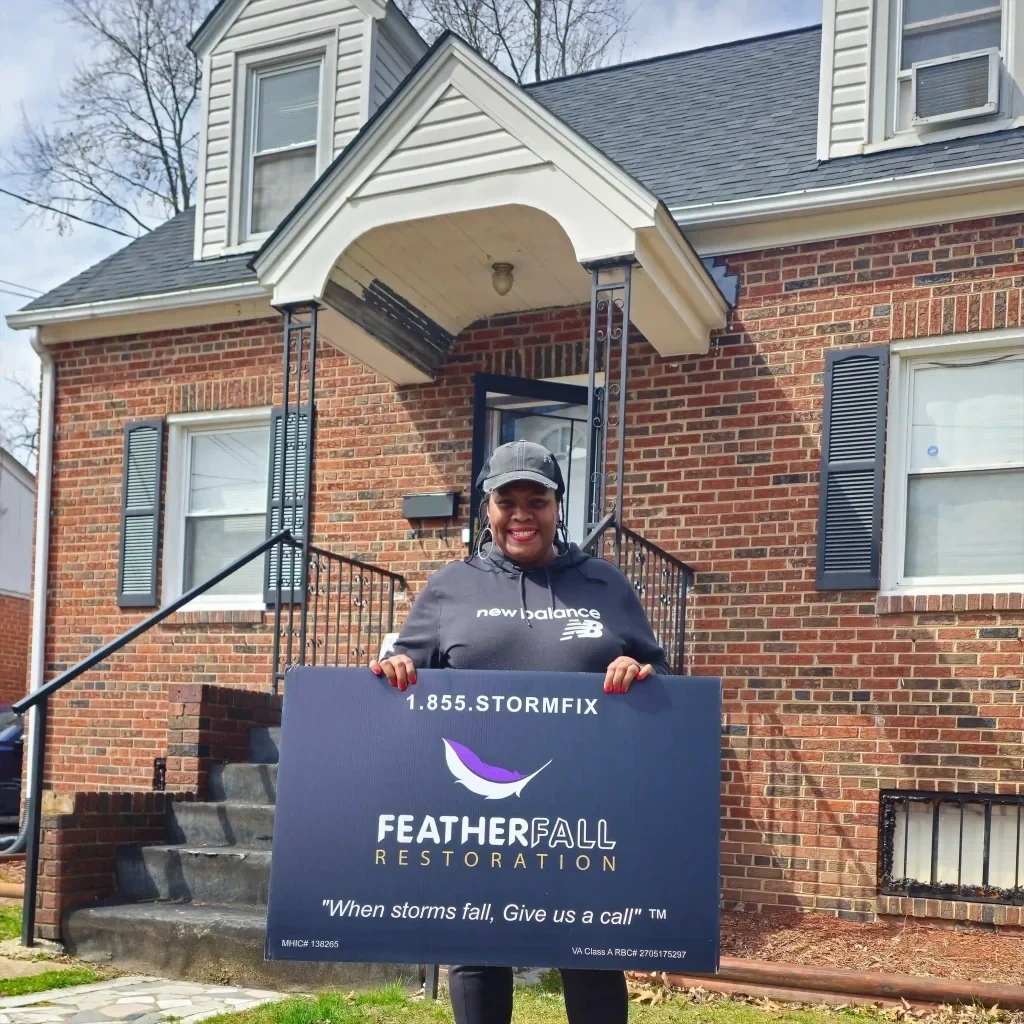 Happy homeowner holding FEATHERFALL yard sign
