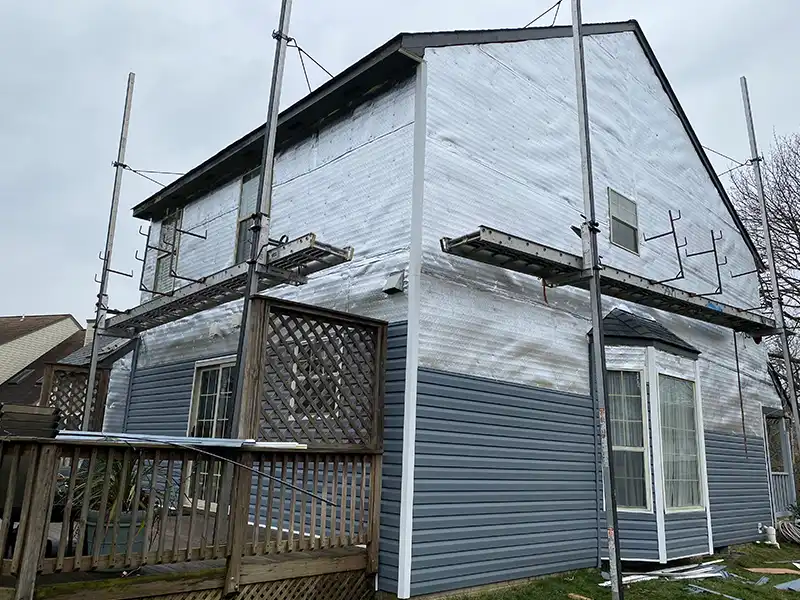 New blue vinyl siding being installed on house in Maryland