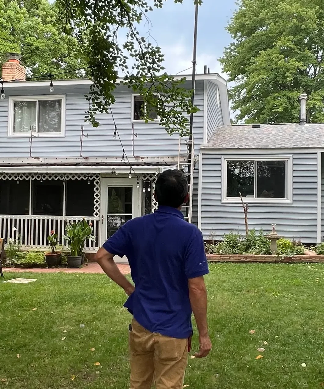 A Featherfall customer with his back to the camera watching us finish his siding replacement.